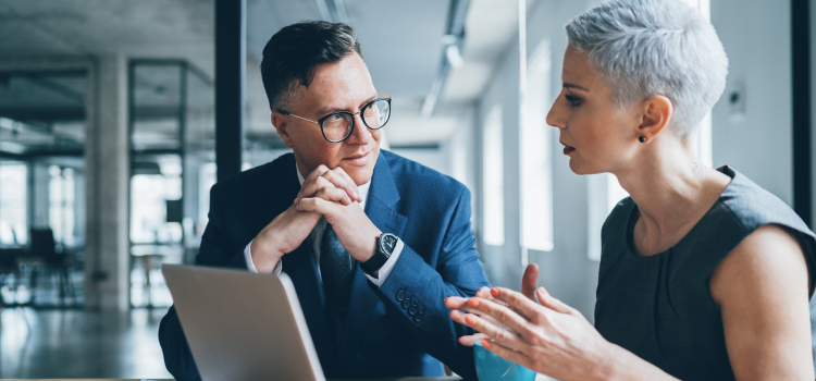 Photo of a man and woman speaking in an office 