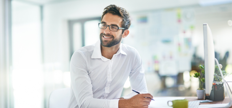 Photo of a man smiling at his desk