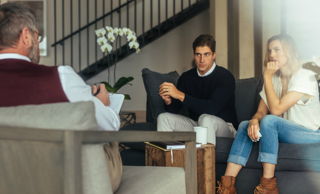 A man and a woman amid a divorce discussing with their lawyer.