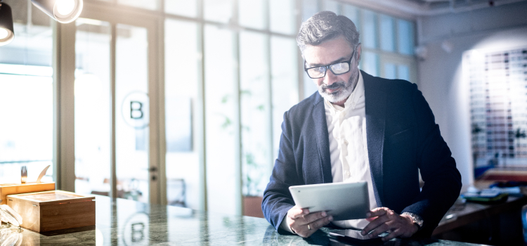 Picture of a man looking at his tablet.
